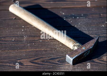 Old vintage hammer on a wooden background, close-up, selective focus Stock Photo