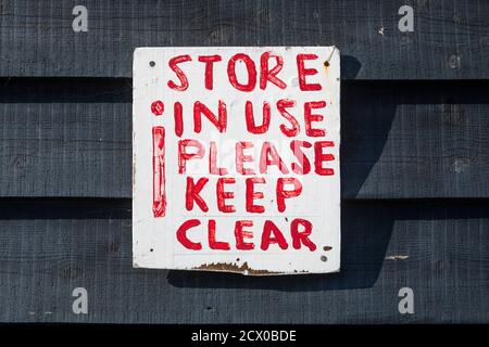 A roughly painted keep clear sign on a wooden wall Stock Photo
