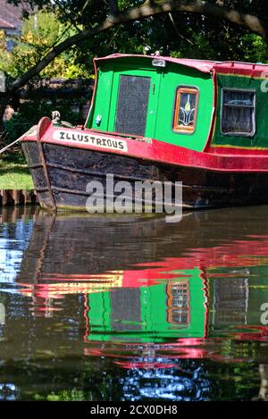 Abstract shapes created by the reflections of brightly painted narrow boat in water