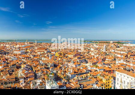 Aerial panoramic view of Venice city old historical centre, buildings with red tiled roofs, churches and bell towers background, Veneto Region, Northern Italy. Amazing Venice cityscape. Stock Photo
