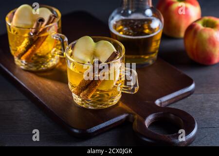 Hot apple cider cocktail with cinnamon and apple slices. Mulled apple wine for Christmas. Stock Photo