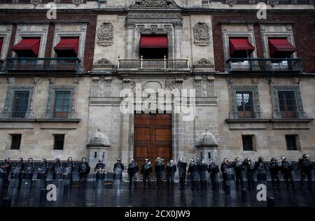 Police stand outside the former presidential palace and underneath the balcony where Mexico's President Enrique Pena Nieto is due to lead his first traditional remembrance of the heroes of Mexican independence, in Mexico City September 13, 2013. Police used tear gas and water cannons to disperse demonstrators in the main square of Mexico City on Friday, arresting 31 people, as the government took control of the historic center after weeks of protests by teachers. Federal police clashed with some protestors as they cleared the massive square, or Zocalo, for celebrations on Sunday. REUTERS/Tomas