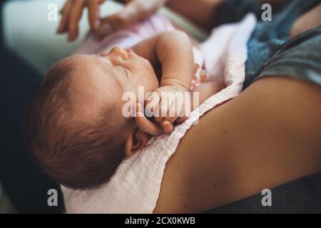 Upper view photo of a caucasian newborn girl sleeping while embraced by her careful mother Stock Photo