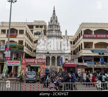 Puri, India - February 3, 2020: Street view of traffic in front of a small white hindu temple close to Jagannath on February 3, 2020 in Puri, India Stock Photo