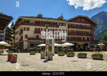 View of Brocherel square in the centre of the famous mountain town with people in outdoor cafe in summer, Courmayeur, Aosta Valley, Italy Stock Photo