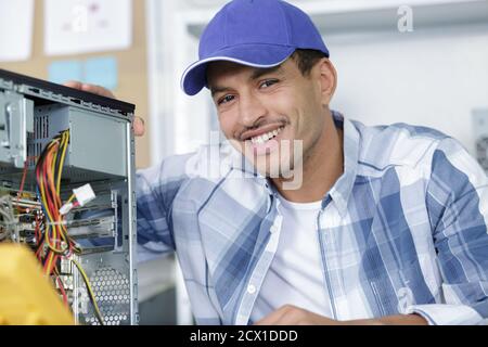 smiling man using multimeter while fixing pc Stock Photo