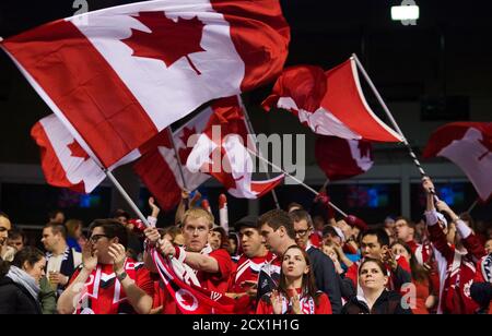 Canadian fans wave flags prior to their CONCACAF women's Olympic qualifying soccer match against Cuba in Vancouver, British Columbia January 21, 2012. REUTERS/Andy Clark (CANADA - Tags: SPORT SOCCER OLYMPICS)