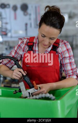 female mechanic repairing car in body shop Stock Photo