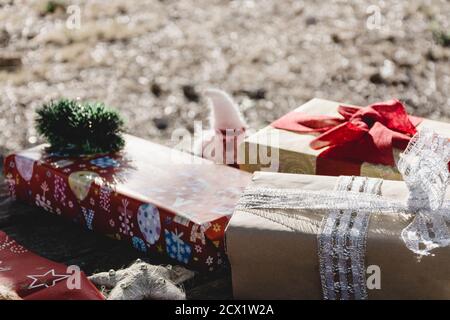 Gift boxes and Christmas decorations on a picnic table in the countryside at sunset Stock Photo
