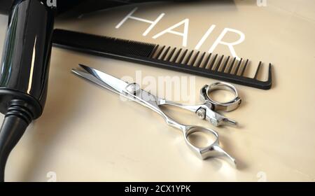 Hairdresser Tools, cutting comb and scissors, a green plant Stock Photo