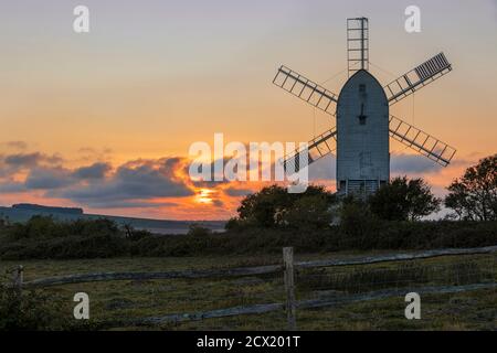 Watching the sun go down behind Ashcombe mill and the south downs on the Kingston Ridge near Lewes in east Sussex south east England Stock Photo