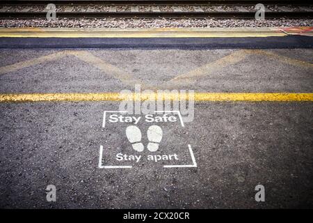 Stay safe, stay apart stencil at the platform edge on Milton Keynes railway station Stock Photo