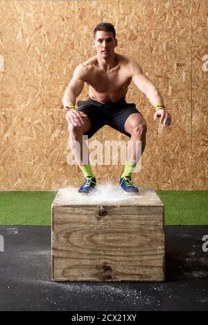 Fit man jumping on a gym box for workout Stock Photo