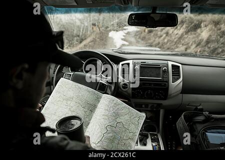 Man reading map while traveling in car Stock Photo
