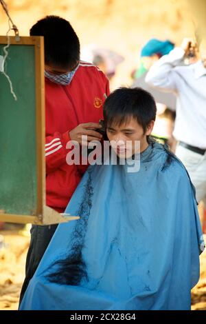 Vietnamese man at Can Cau market smoking from a bamboo water bong Stock ...