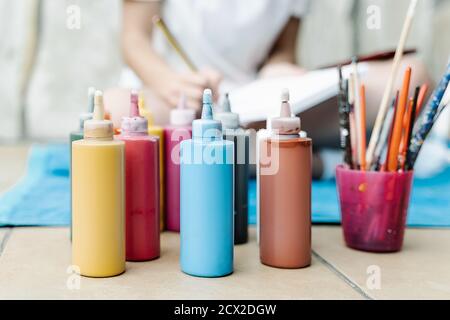 Female hand shakes the brush and soaks in watercolor paints. The photo  shows pencils, brushes, paints, pens and white paper Stock Photo - Alamy