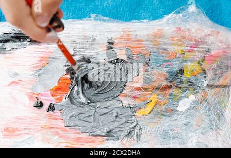 hand with a brush mixing a color painting on a painting palette. Overhead horizontal photo Stock Photo