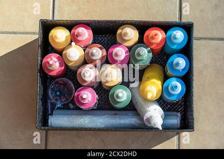 many painting pots in several color in a black box on the floor. Overhead horizontal photo Stock Photo