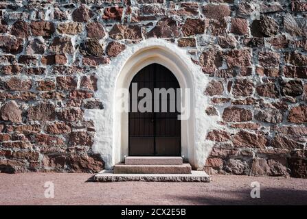 old wooden door under a stone arch old building Stock Photo