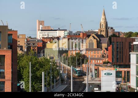 Nottingham, England - November 10, 2020: A modern electric tram pulls into a station in Nottingham City centre, with the famous Lace market district. Stock Photo