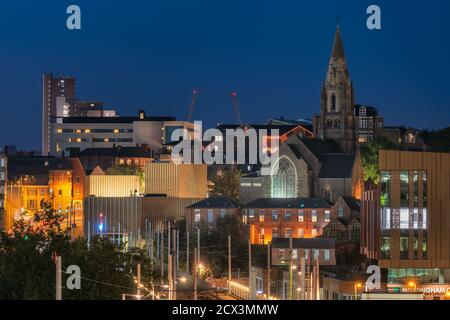 Nottingham, England - November 10, 2020: A modern electric tram pulls into a station in Nottingham City centre, with the famous Lace market district. Stock Photo