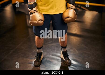 Athletic man in shorts standing on a ring floor Stock Photo