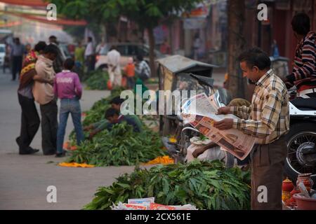 Indian street vendors and man reading newspaper, Jaipur, Rajasthan, India Stock Photo
