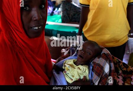 Asiah Dagane Hussein, a refugee from Somalia holds Minhaj Gedi Farahi, her severely malnourished seven-month-old child inside the stabilization ward in the International Rescue Committee, (IRC) field clinic at the Hagadera refugee camp in Dadaab, near the Kenya-Somalia border, July 30, 2011. Minhaj was admitted to the hospital with severe pneumonia, acute severe malnutrition and diarrhoea but has since showed remarkable improvement and now weighs 3.4kg (7 pounds, 8 ounces) and has started breastfeeding according to the IRC doctors.  REUTERS/Thomas Mukoya (KENYA - Tags: SOCIETY CIVIL UNREST DIS