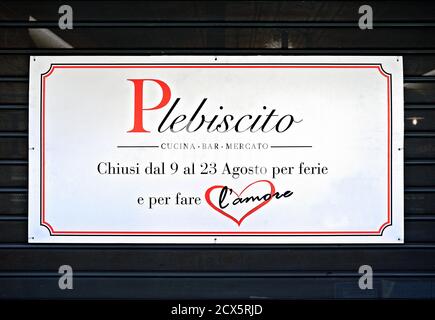 Closed for holiday and to make love, written on a closed shutter of a bar, restaurant, market. Summer season holidays. Rome, Italy, Europe