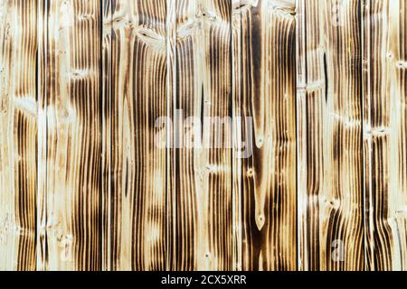 Old burnt wooden plank brown background with vertical boards. Flat lay close-up view. Stock Photo