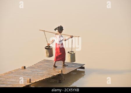 Burmese woman collecting water from a reservoir between Mount Popa and Bagan Burma. Myanmar. Water Festival preparations Stock Photo