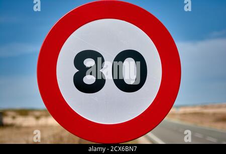 detail of a round traffic sign with red border and black limit number 80 km/h mph Stock Photo