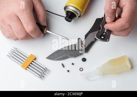 Man repairing a folding knife on white background Stock Photo