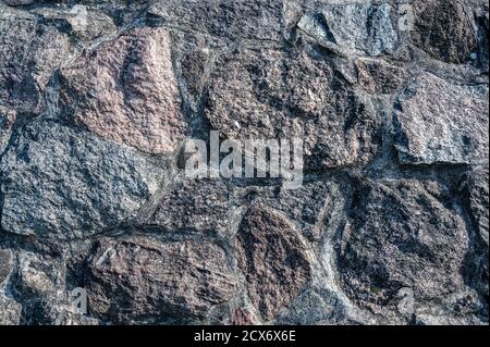 Background of the wall of large granite textured stones, horizontal view Stock Photo
