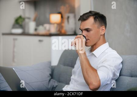 man drinking coffee relaxing on the couch at home Stock Photo