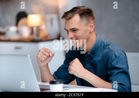 happy young man reading the news on his laptop. Stock Photo