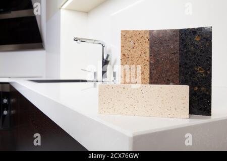 Different quartz kitchen counter top samples on white polished countertop with precise processed edges. Stock Photo