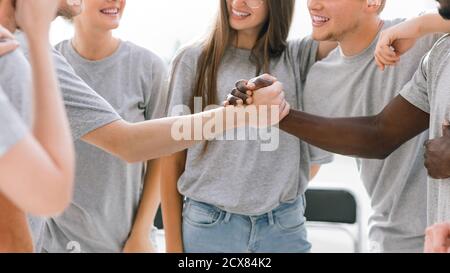 two guys shaking hands standing in a circle of friends Stock Photo