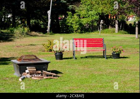 Self contained fire pit and red bench Stock Photo