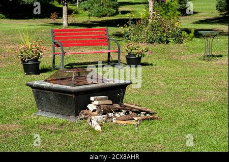 Self contained fire pit and red bench Stock Photo