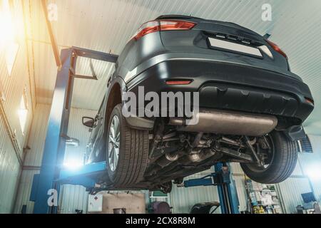 Modern SUV Auto on lift in Car Service for diagnostics, maintenance and repair. Stock Photo