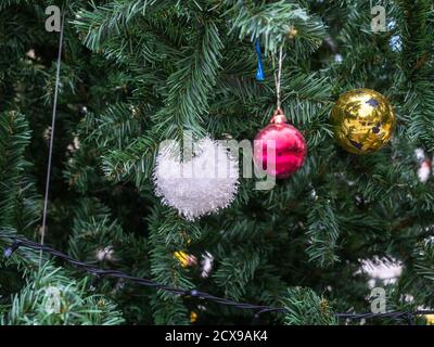 Fragment of an artificial Christmas tree with multi-colored shiny decorations Stock Photo