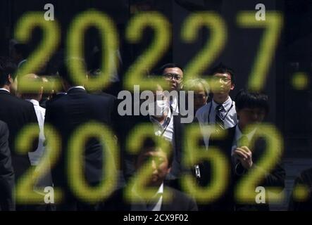 Men Are Reflected On An Electronic Board Displaying Japan S Nikkei Share Averages Outside A Brokerage In Tokyo April 23 2015 For Market Indices Round Numbers Have Little More Than Symbolic Meaning Even