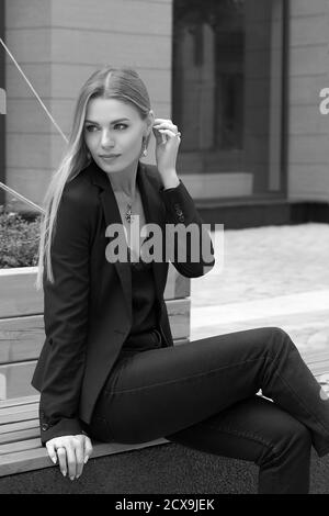 businesswoman in a black suit walks through the summer city. Stock Photo