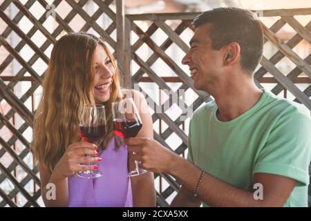 Happy Moment With a Mixed Race Couple Drinking Wine and Laughing. Couple Drinking Concept Stock Photo
