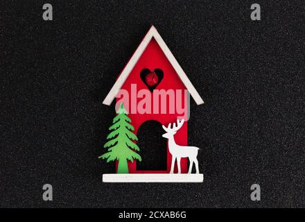 Christmas flatlay layout. wooden toy house, a deer and a Christmas tree on a black glitter shiny background. Christmas card with place for text Stock Photo