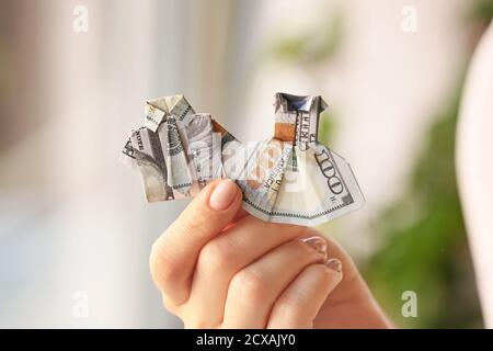 Woman with origami figures made of dollar banknotes at home, closeup Stock Photo