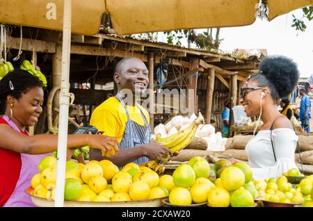 a young handsome african man feeling excited as he sells to his beautiful customer while his colleague hold a point of sales machine Stock Photo