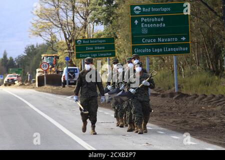 Soldiers arrive to clear the ash that fell from Calbuco volcano in Ensenada town, May 2, 2015. Chilean volcano Calbuco erupted for the third time in eight days on Thursday, sending a new cloud of ash and gas high into the sky, although officials said the latest eruption was less powerful than those of last week. Picture taken May 2, 2015. REUTERS/Carlos Gutierrez