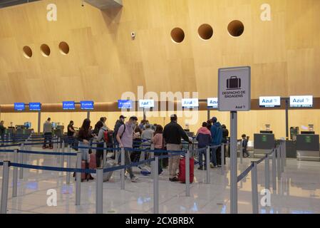 Florianopolis, Brazil. September 19, 2020: Queue to check baggage at the airport. People crowded during the pandemic. Written sign Checked baggage (De Stock Photo